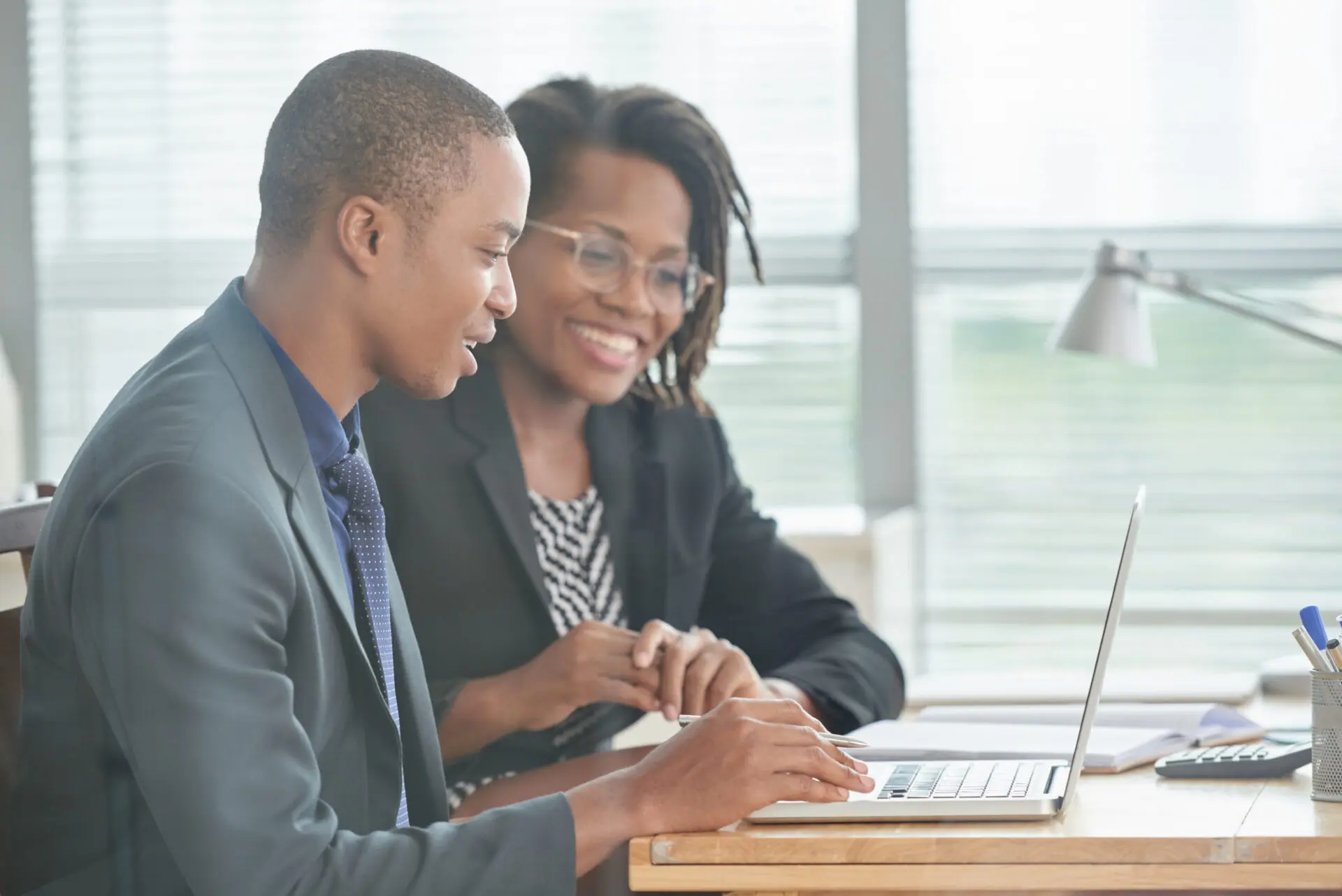man and woman seated in front of laptop