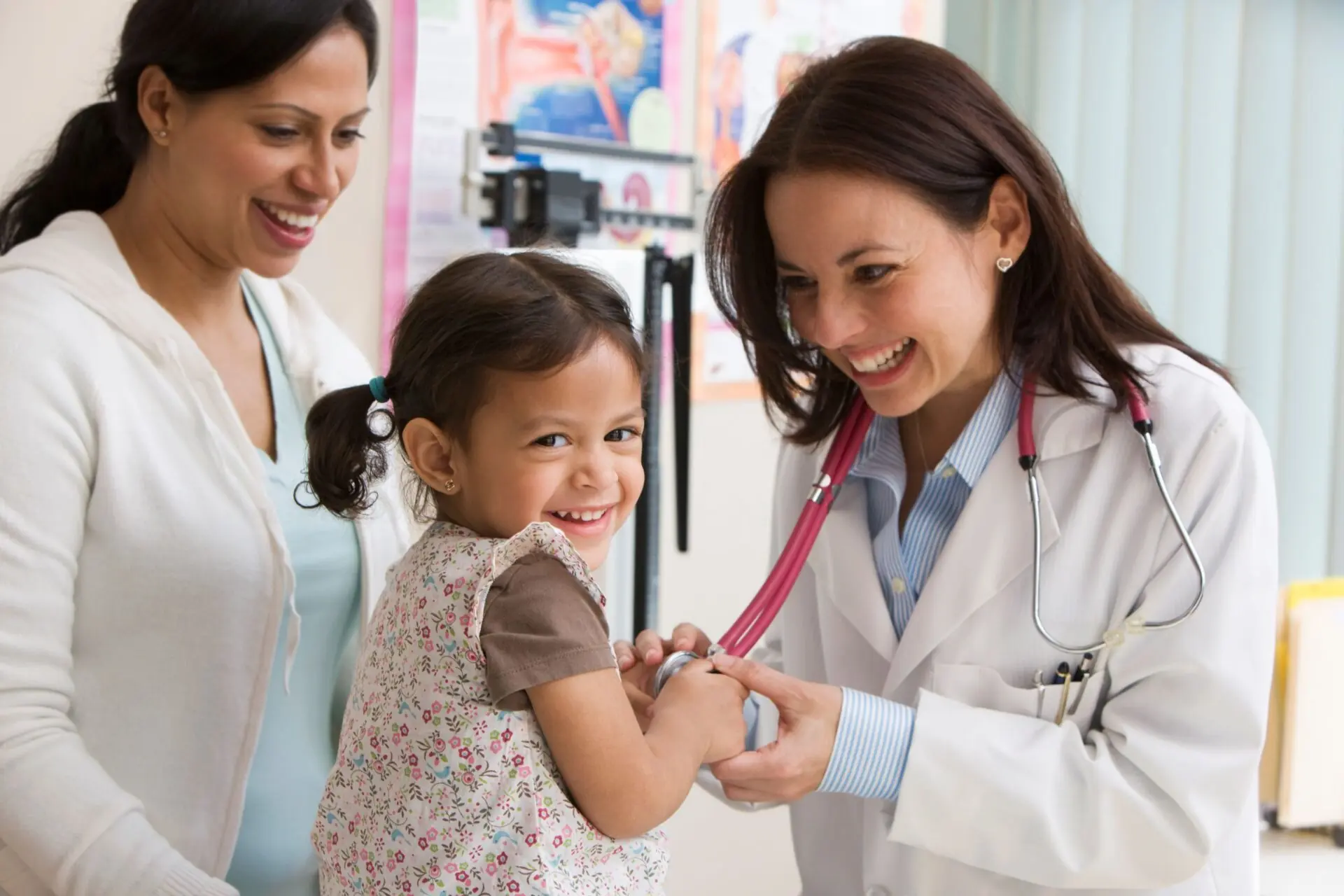 woman doctor with child patient and her parent
