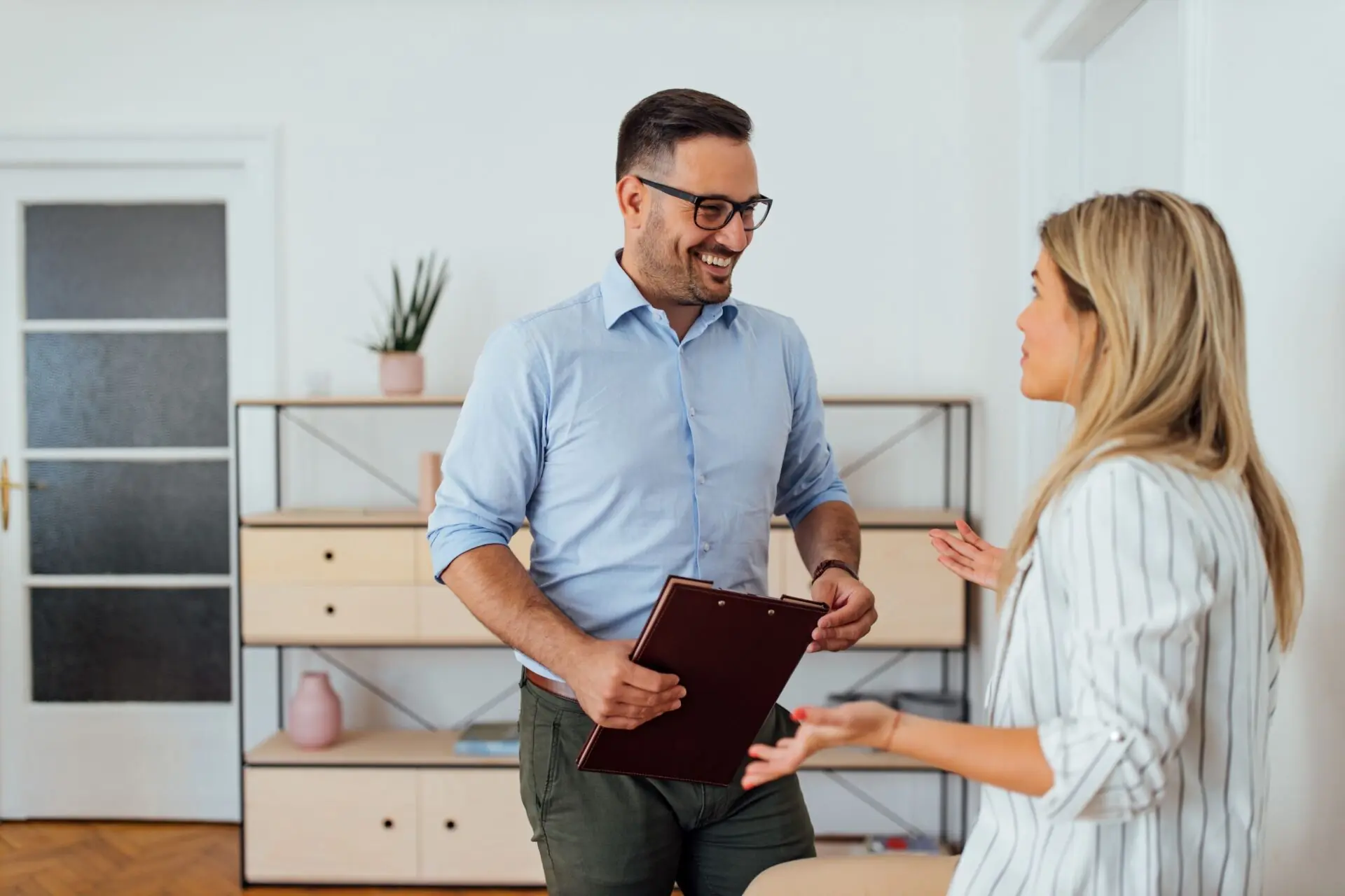 smiling businessman holding clipboard with woman coworker
