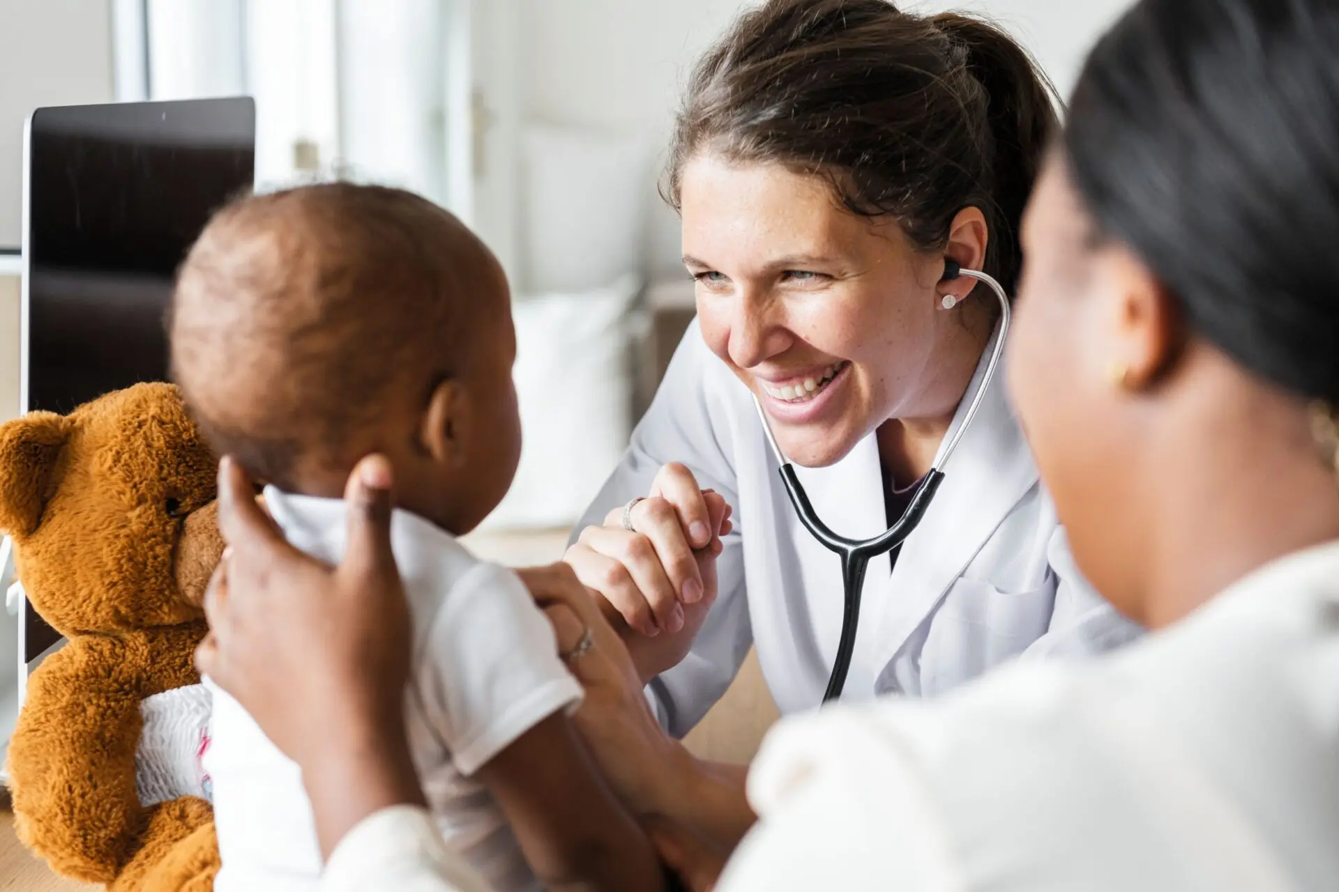 Female doctor visiting child with teddy bear