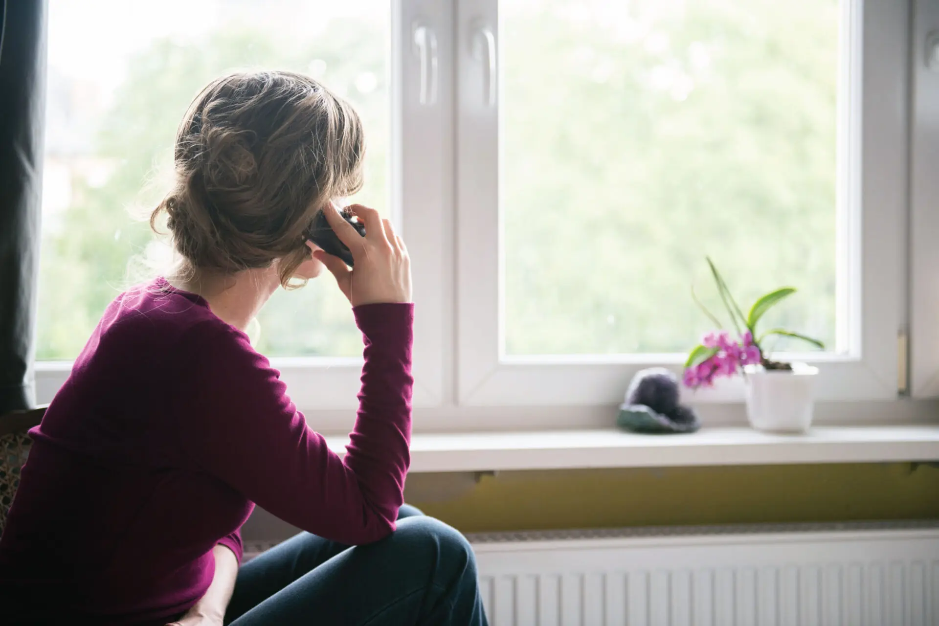Women on phone looking out window
