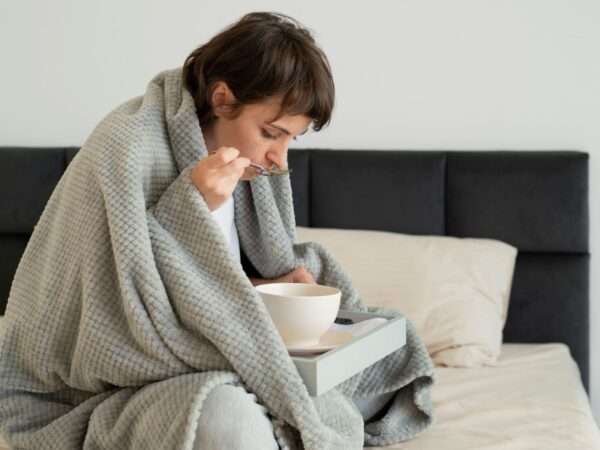 woman at home sick eating soup