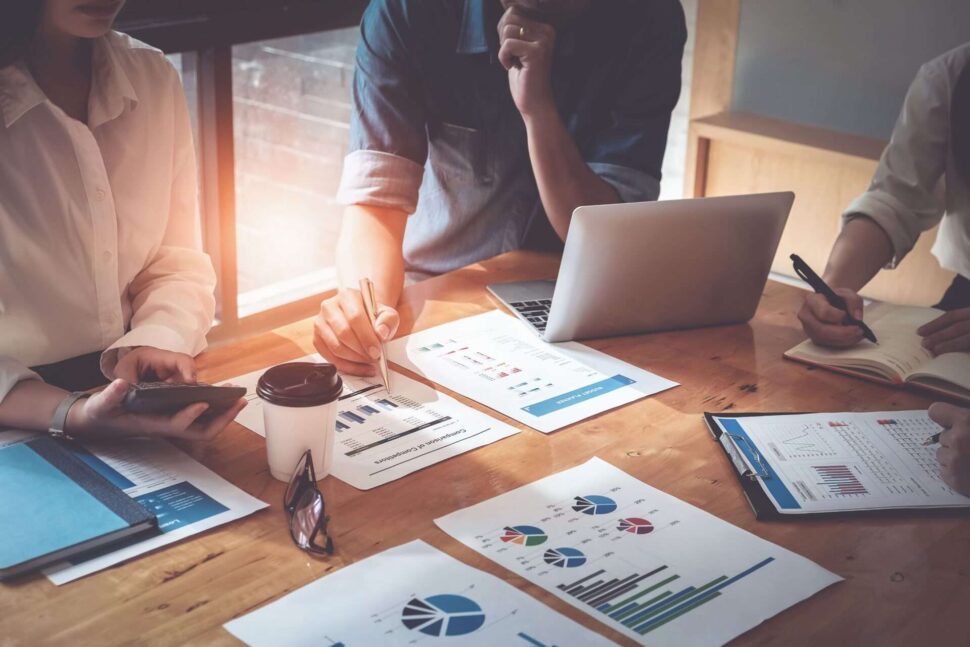 people at a desk working on reports