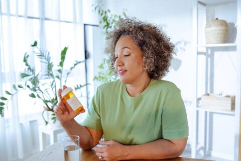 Woman reading pill bottle