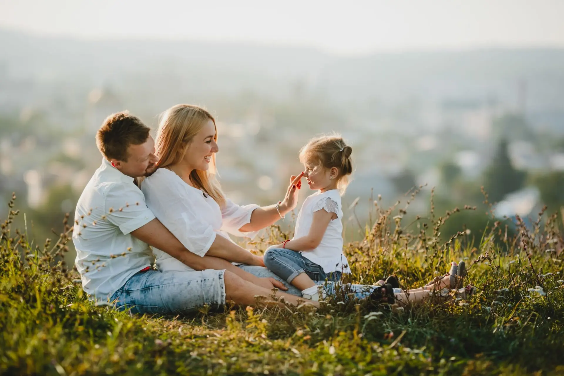 parents sitting on grass with child