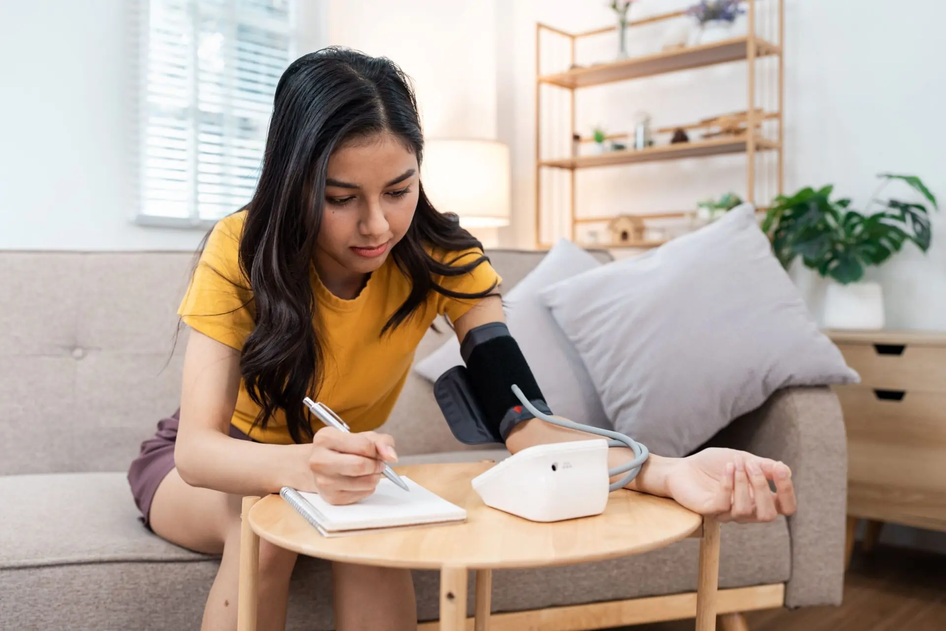Young person taking blood pressure at home