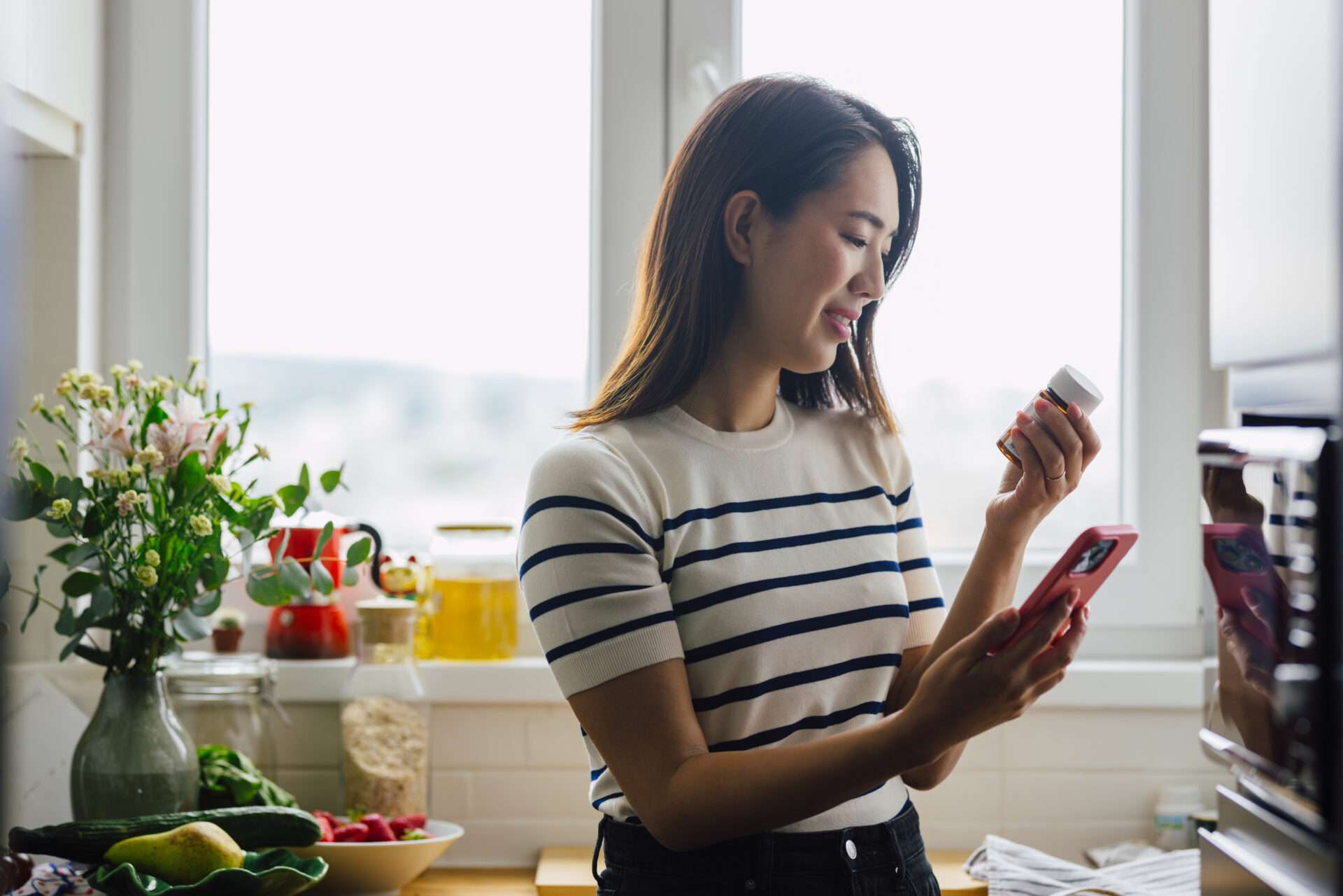 Woman standing and reading pill bottle