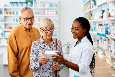 husband and wife talking with a female pharmacist