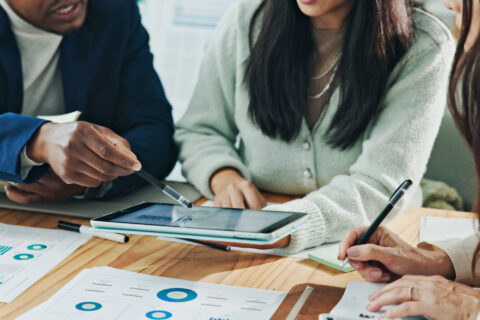 Business colleagues holding a tablet looking at reports