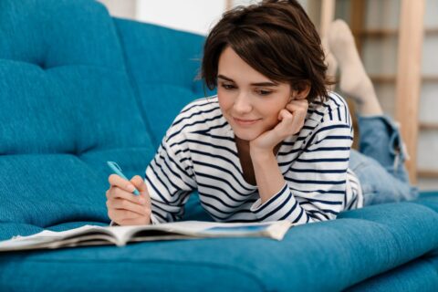 Woman doing homework on couch