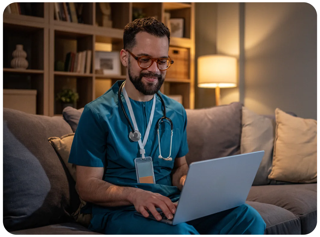 Doctor wearing glasses working on his laptop
