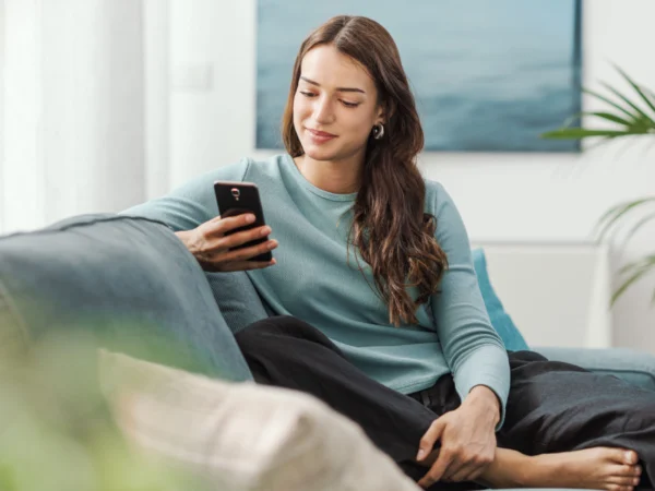 Woman in blue sweater looking at phone