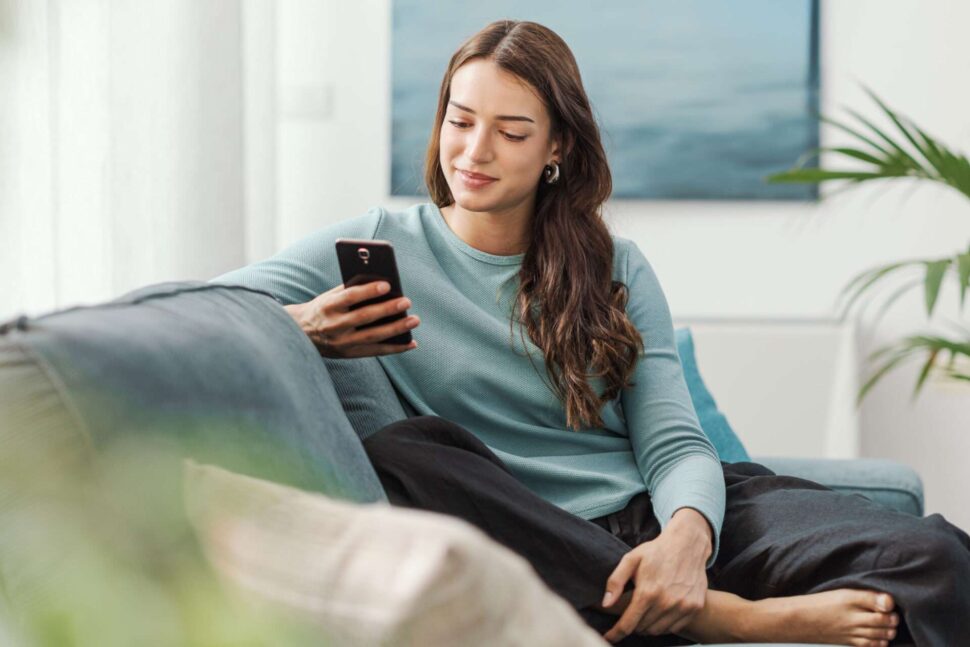 Woman in blue sweater looking at phone