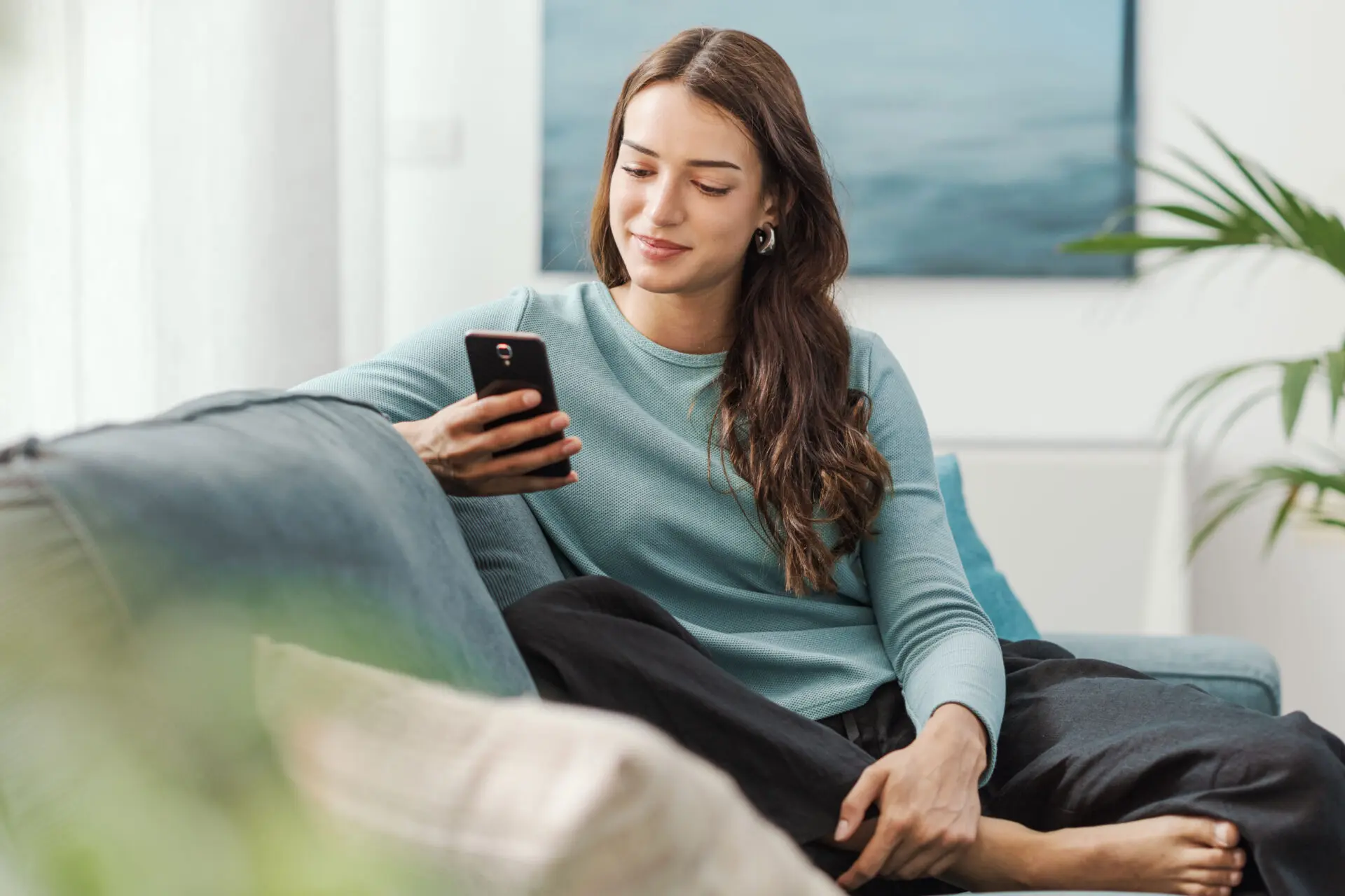 Woman in blue sweater looking at phone